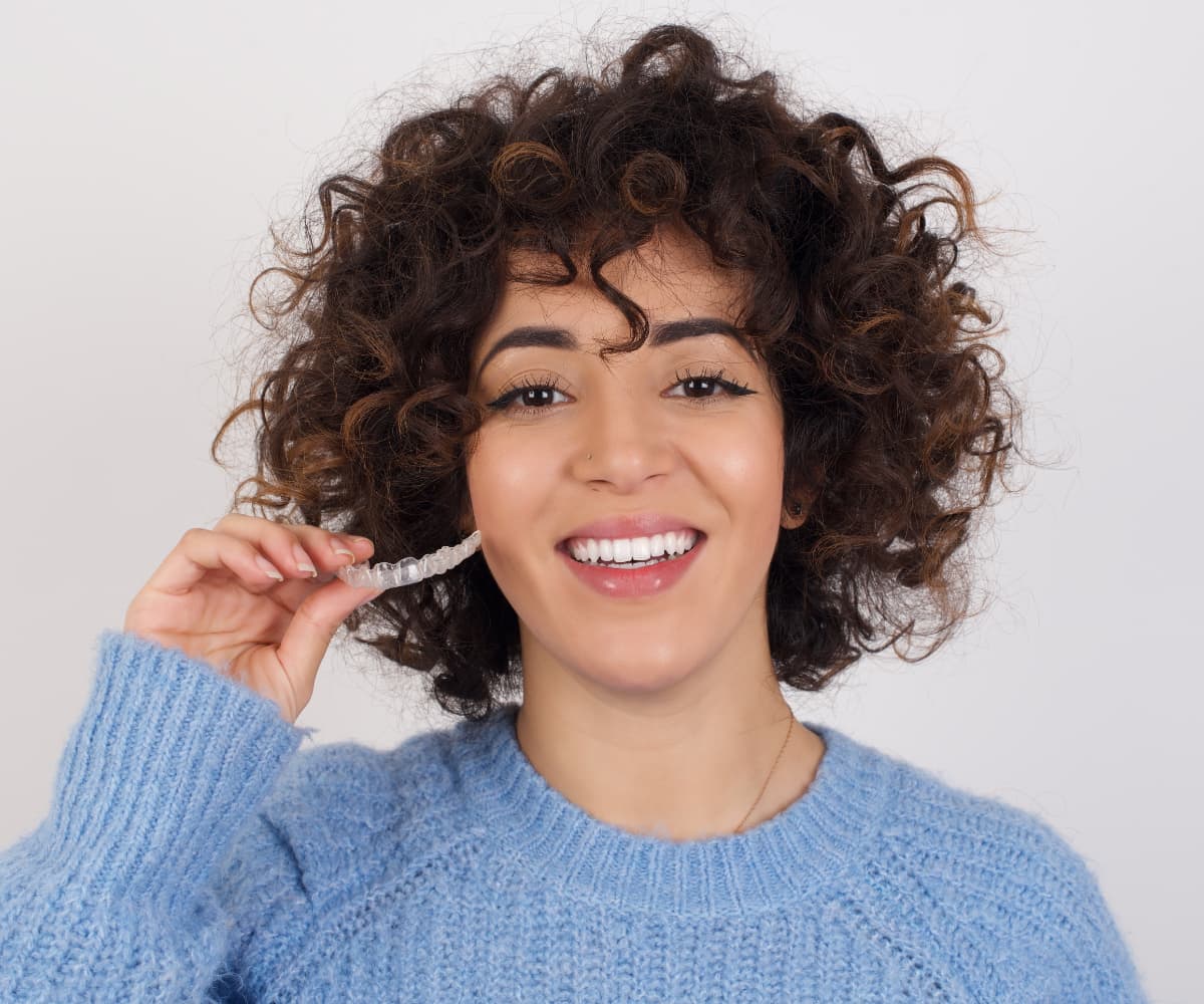 teen girl holding invisalign aligners